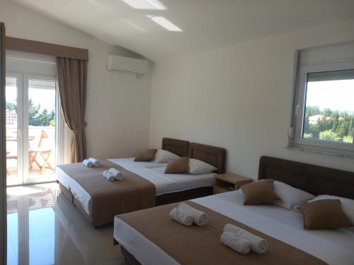 a bedroom with two beds and a balcony at Vila Nina Donji Štoj in Ulcinj