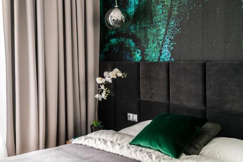 een slaapkamer met een bed met een groen kussen erop bij Old Town - River Point by Welcome Apartment in Gdańsk