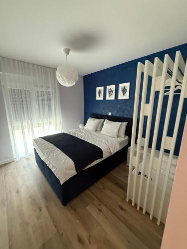 a bedroom with a large bed with a blue wall at Aqua Azzuro Lovran in Lovran