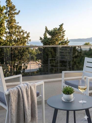 a table and chairs on a balcony with a glass of wine at Apartman SOFI in Ulcinj