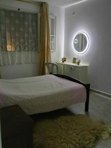 a bedroom with a bed and a mirror and a rug at Darna in Raʼs al Jabal