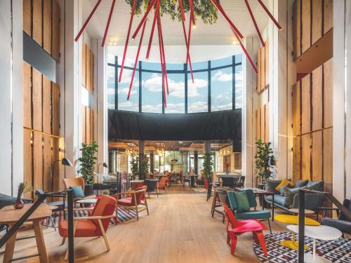 a lobby with chairs and tables and a large window at Novotel Paris Vaugirard Montparnasse in Paris