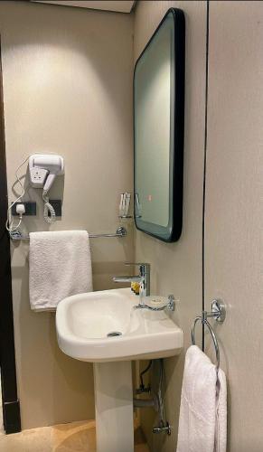 a bathroom with a sink and a tv on the wall at سديم الفجر للنزل السياحية بيوت عطلات وشاليهات - فئه اقتصادى in Taif