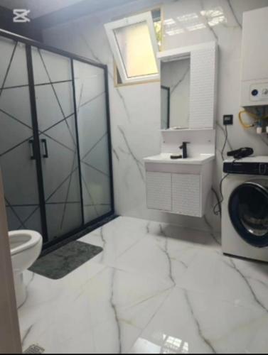 a white bathroom with a sink and a washing machine at Qebele gunluk ev in Bum