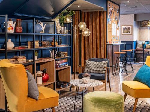 a room with chairs and a table and a bar at ibis Paris Grands Boulevards Opéra 9e in Paris