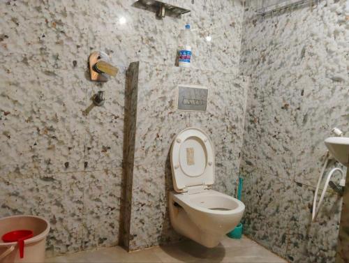 a bathroom with a toilet and a sink at BHS Deluxe Rooms in Puri
