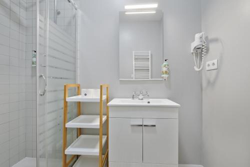 a white bathroom with a sink and a shower at Mouzinho 244 - Porto Houses & Suites in Porto