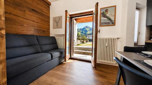 a living room with a couch and a table at Hostdomus - Royal Oak in Sestriere