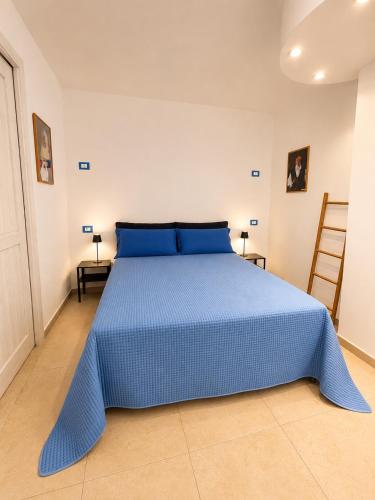 a blue bed with blue pillows in a bedroom at VR-Room in Forte Village