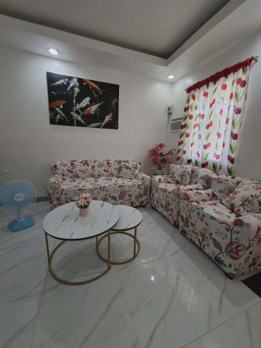 a living room with a couch and a table at Compostela Two Story Richwood Townhome Breakfast Offered in Compostela