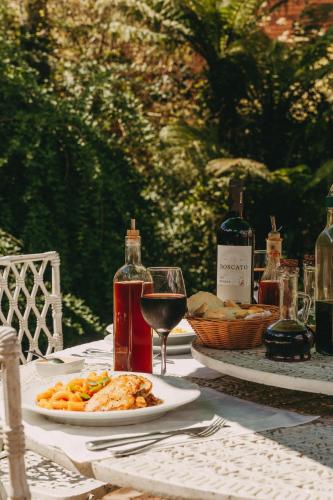 ein Tisch mit einem Teller Essen und einem Glas Wein in der Unterkunft Farina Park Hotel in Bento Gonçalves