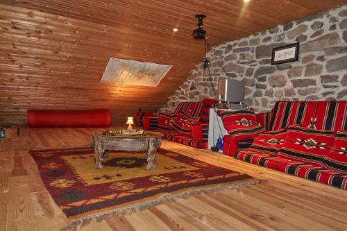 a living room with red couches and a stone wall at Ferme de Chaudeyrac in Saint-Front