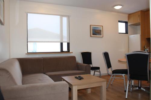 a living room with a couch and a table at Ormurinn Guesthouse in Egilsstadir