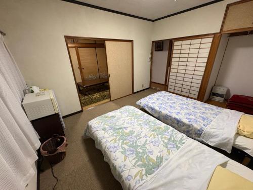a room with two beds and a phone in it at 民泊SakuraワンちゃんＯＫ in Karatsu