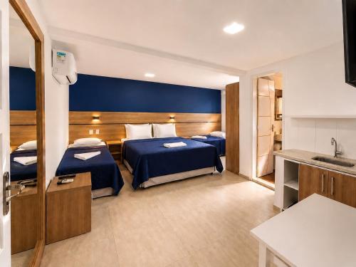 a hotel room with two beds and a sink at Pousada da Prainha in Arraial do Cabo