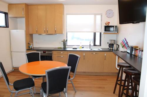 a kitchen with a table and chairs in a kitchen at Ormurinn Guesthouse in Egilsstadir