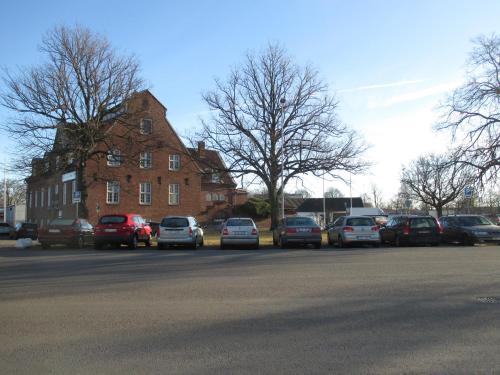 a parking lot with cars parked in front of a building at Halmstad Hotell & Vandrarhem Kaptenshamn in Halmstad