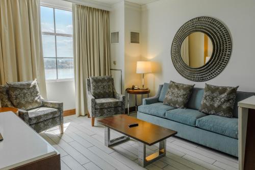 a living room with a couch and chairs and a mirror at Bally's Evansville Casino & Hotel in Evansville