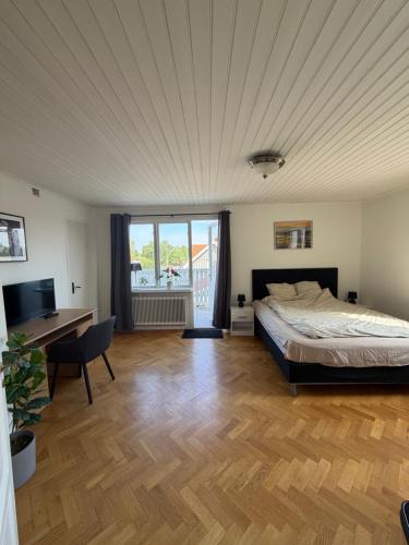 a bedroom with a bed and a desk and a television at Grevgatan 4 Apt 1101 in Eksjö