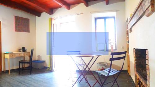 a room with a table and chairs and a desk at Odyssée auvergne in Vallon-en-Sully