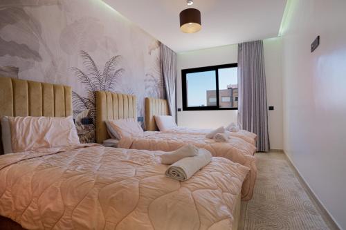 a bedroom with two beds with towels on them at flora bay luxe in Agadir