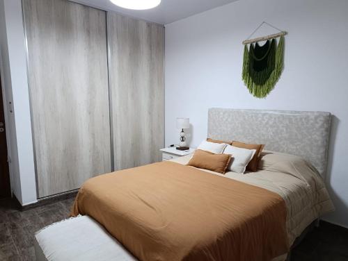 a bedroom with a large bed with a yellow blanket at Oasis urbano! Apartamento Geminis complejo in San Nicolás de los Arroyos