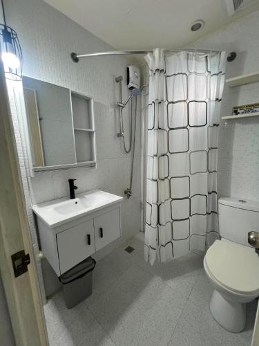 a white bathroom with a sink and a toilet at Compostela Two Story Richwood Townhome Breakfast Offered in Compostela