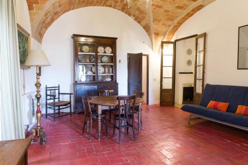 ein Wohnzimmer mit einem Tisch, Stühlen und einem Sofa in der Unterkunft Apartaments Can Gibert in Castelló d'Empúries