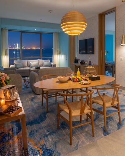 a living room with a table and a couch at Symphony Style Hotel Kuwait in Kuwait