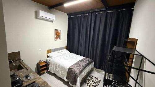 a bedroom with a bed and a black curtain at Flat - Para quem busca tranquilidade e conforto in Goiânia