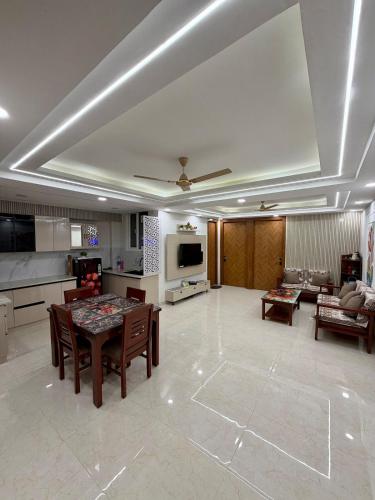 a large living room with a table and a kitchen at Petal & Peak Stays in Rājpur