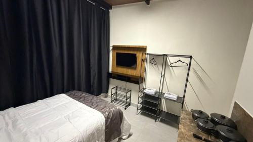 a bedroom with a bed and a television at Flat - Para quem busca tranquilidade e conforto in Goiânia