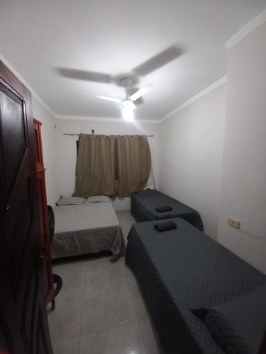 a small room with two beds and a ceiling fan at Apartamento 102 até 9 pessoas com garagem in Ipatinga