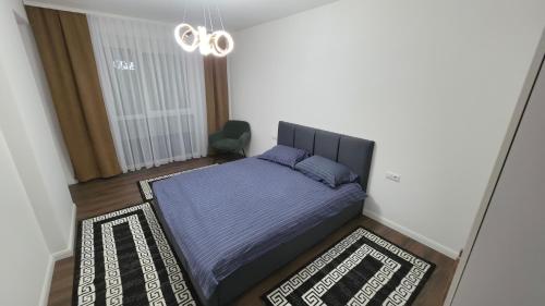 a bedroom with a bed with a blue comforter at Pines Apartment in Kosovo Polje