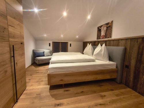 a bedroom with a large bed and a couch at biohof Stiedler in Sankt Johann in Tirol
