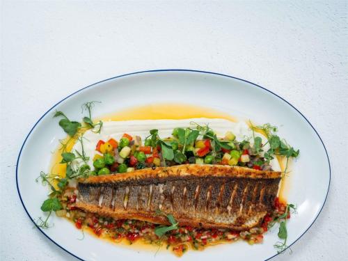a plate of food with a piece of fish and a salad at Sofitel Lafayette Square Washington DC in Washington, D.C.