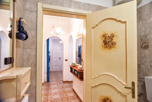 un baño con una puerta que conduce a un pasillo en Villa Gisella, en Punta Prosciutto