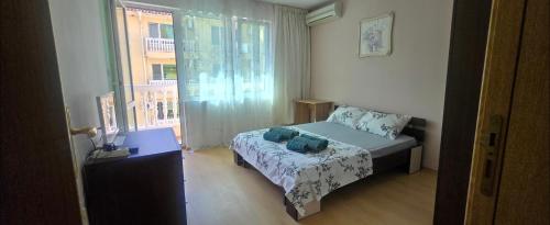 a small bedroom with a bed and a window at Алекс 2 in Pomorie
