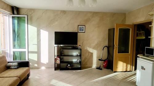 a living room with a flat screen tv on a wall at Алекс 2 in Pomorie