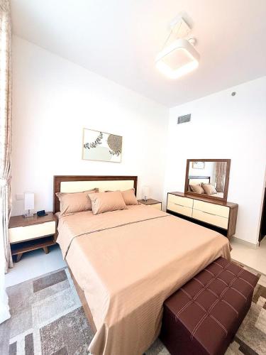 a bedroom with a large bed and a mirror at Ajmal Makan City in Sharjah
