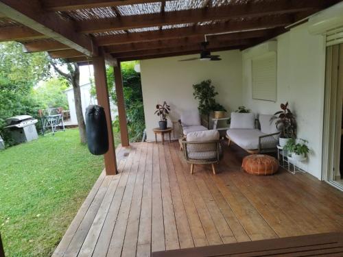a covered patio with a couch and chairs on it at SnirBen zvi in Kibbutz Snir