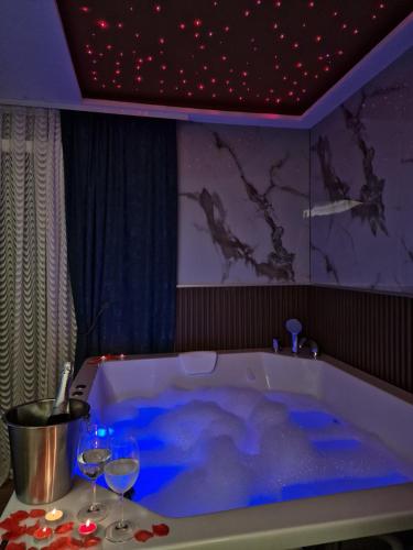 a bathroom with a tub with two wine glasses at Centar Spa Teslic in Teslić