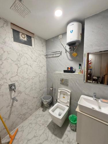 a bathroom with a toilet and a sink at Petal & Peak Stays in Rājpur