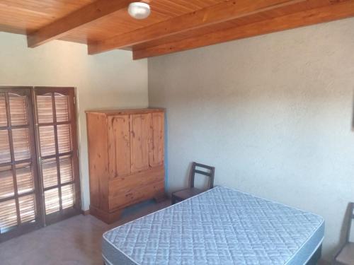 a bedroom with a blue bed and a wooden cabinet at Lo de Rolo in Huerta Grande