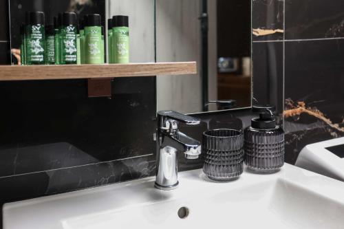 a bathroom sink with a faucet and a mirror at Living in in Afitos
