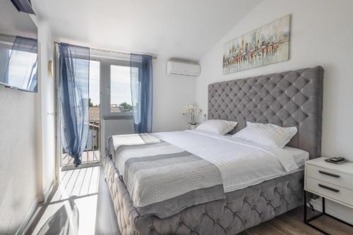 a bedroom with a large bed and a balcony at Little Paradise in Nova Vas