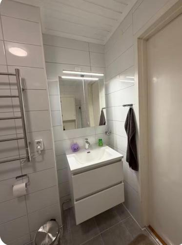 a white bathroom with a sink and a mirror at Grevgatan 4 Apt 1101 in Eksjö