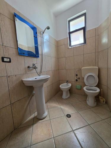 a bathroom with a sink and a toilet and a mirror at Vila Flamuri in Golem