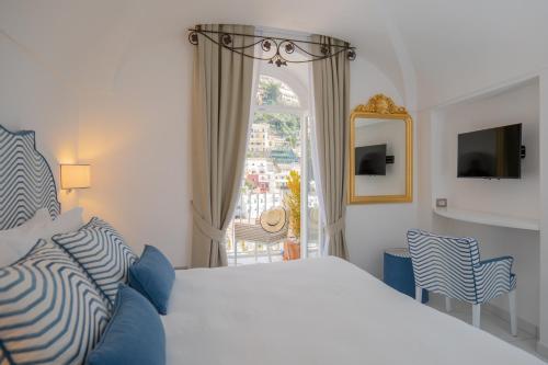 a bedroom with a bed and a large window at Milky Suites Positano in Positano