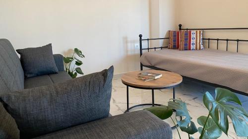 a room with two beds and a table and a couch at Βίλα Αντί Ονείρου-Διαμέρισμα Αμαλία in Kriezá